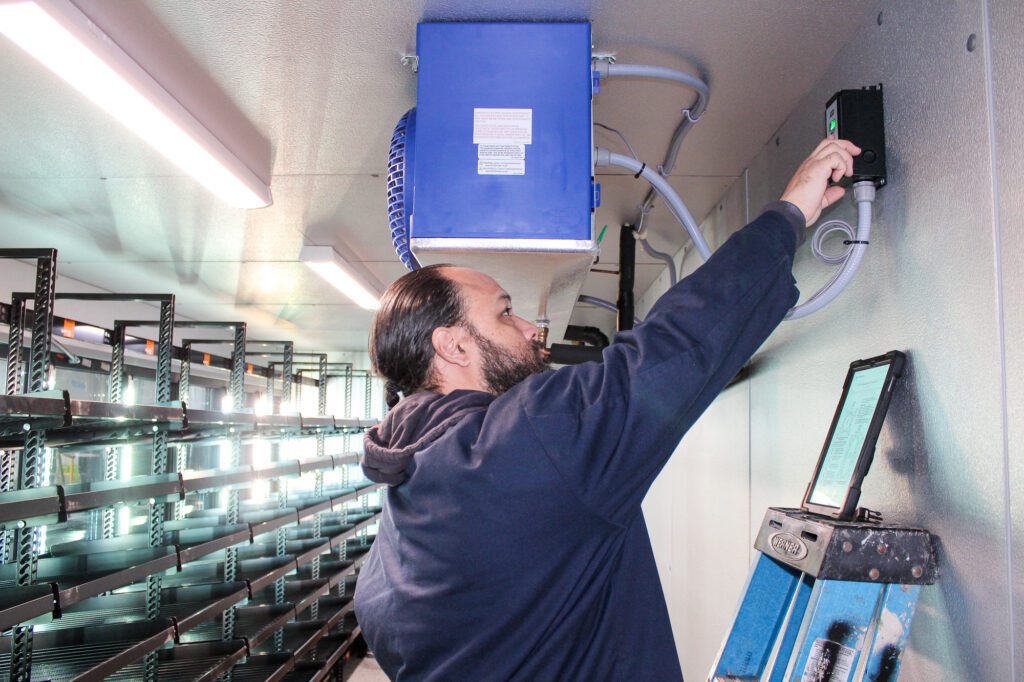 MDi technician servicing a commercial refrigerated display case for food safety and temperature control